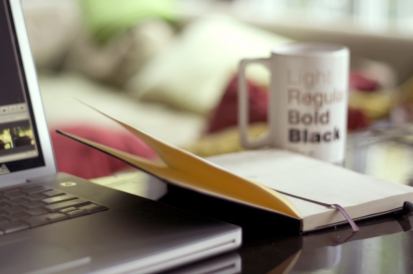 Desk with laptop, notebook and coffee cup