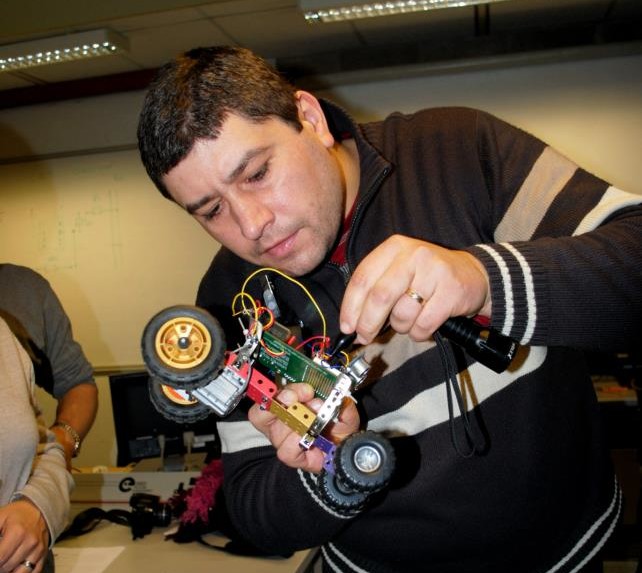 Man using screwdriver to build robot car