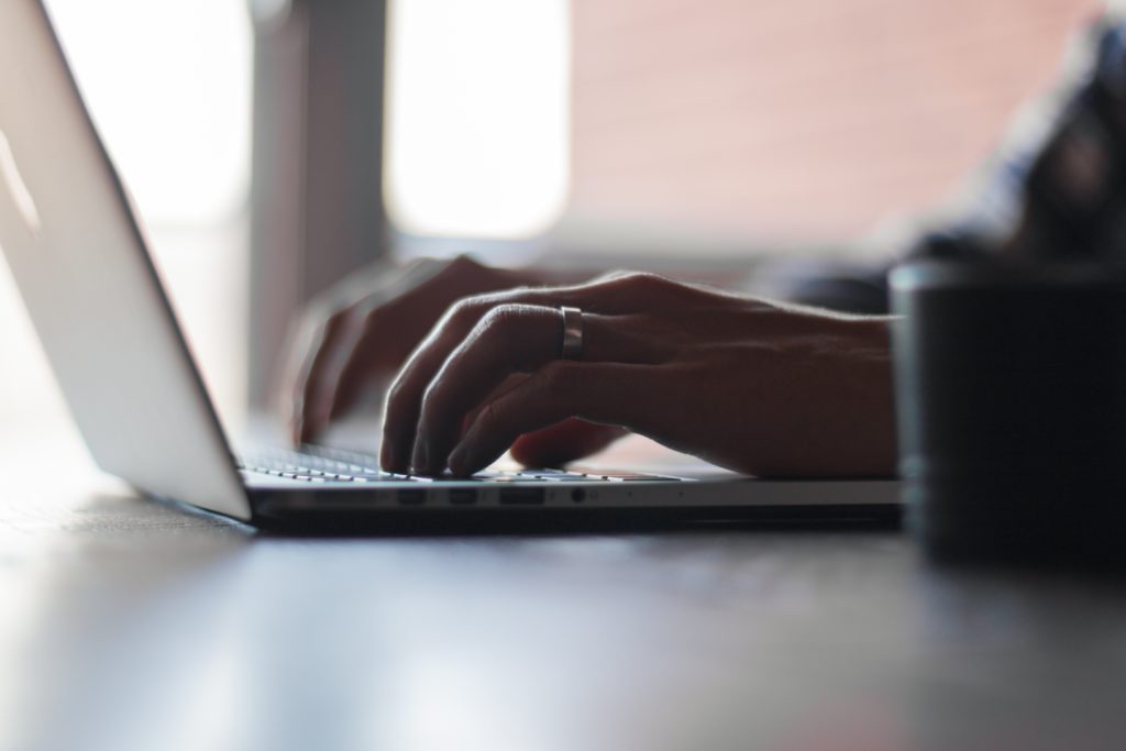 Hands typing on laptop