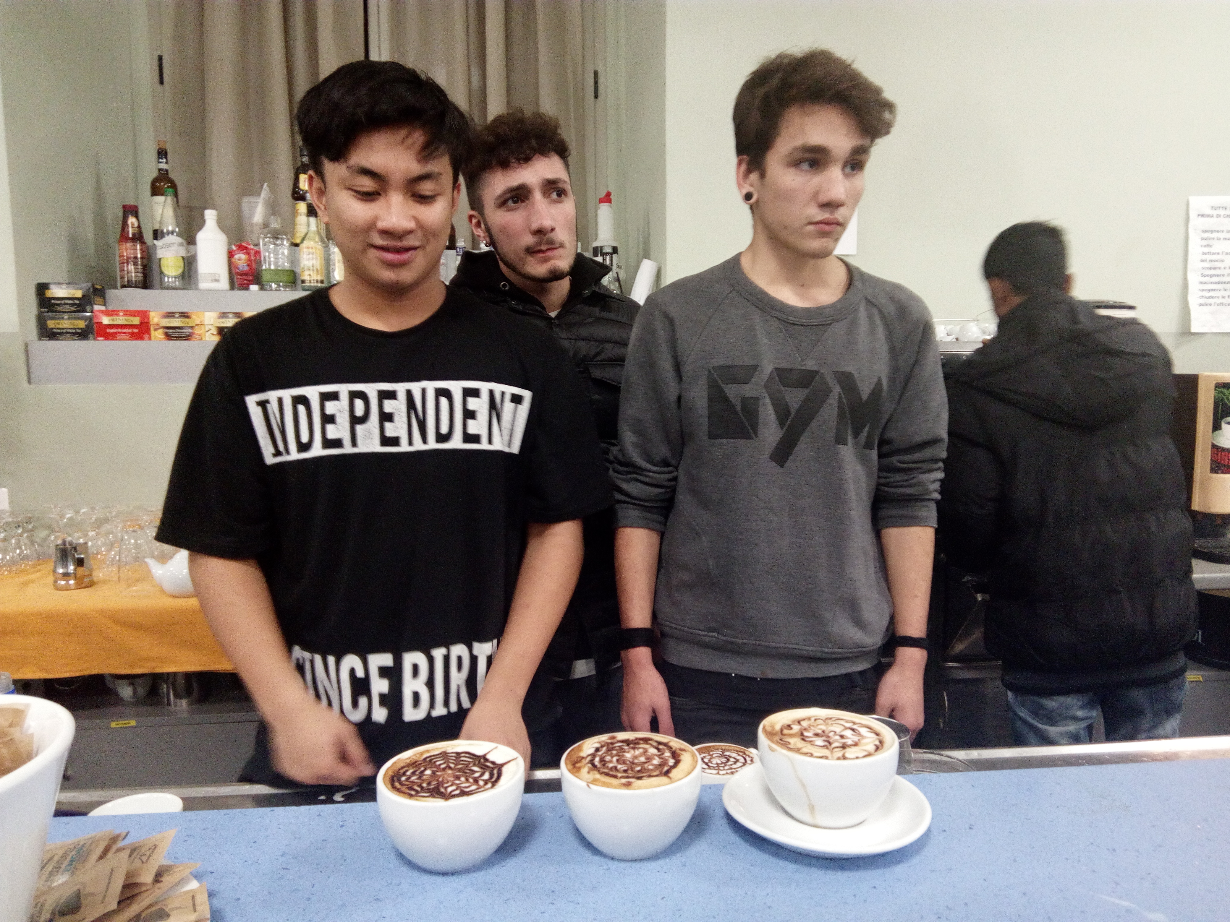 2 boys standing next to 3 capuccinos