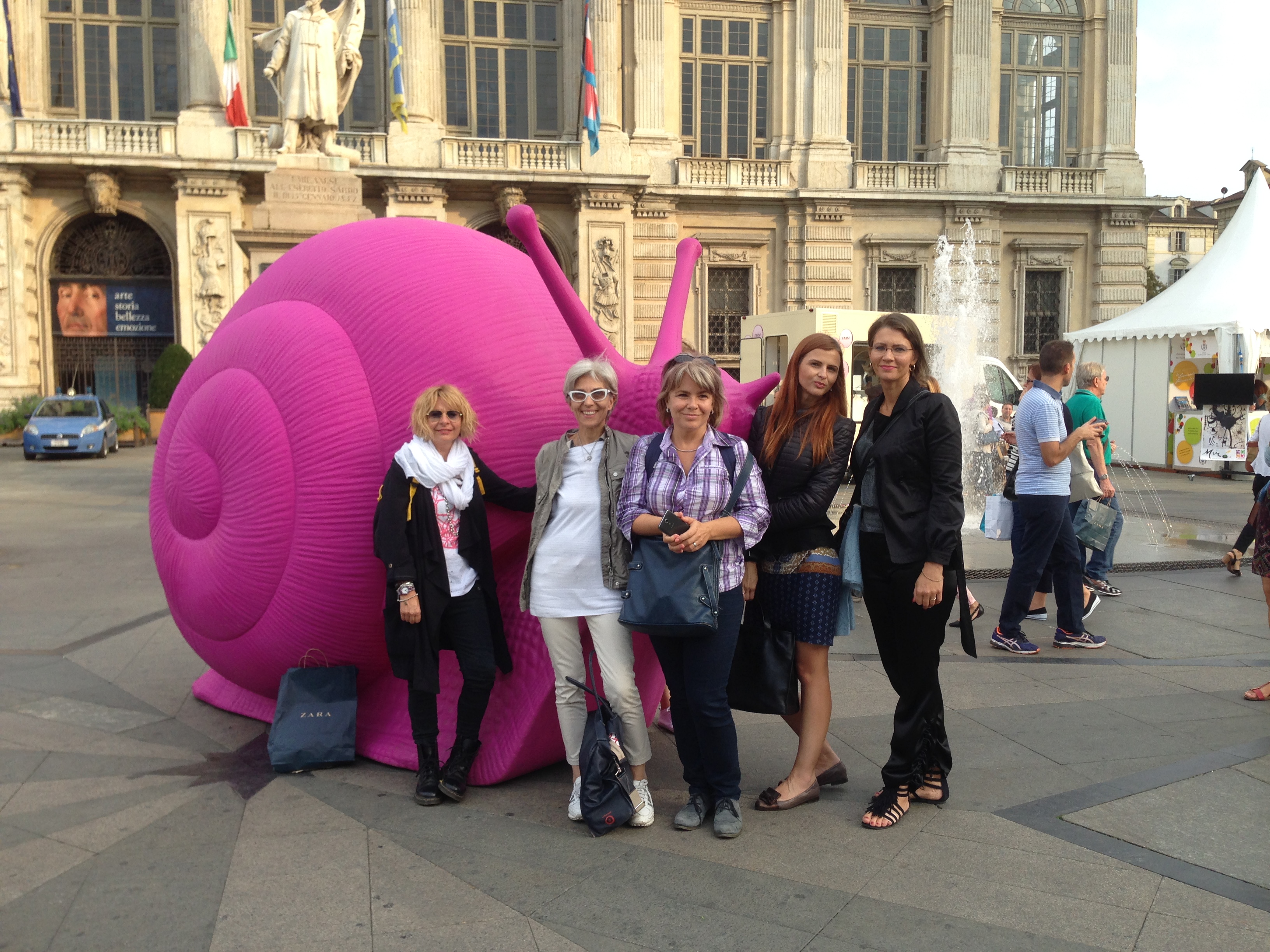 Partners next to sculpture of big pink snail