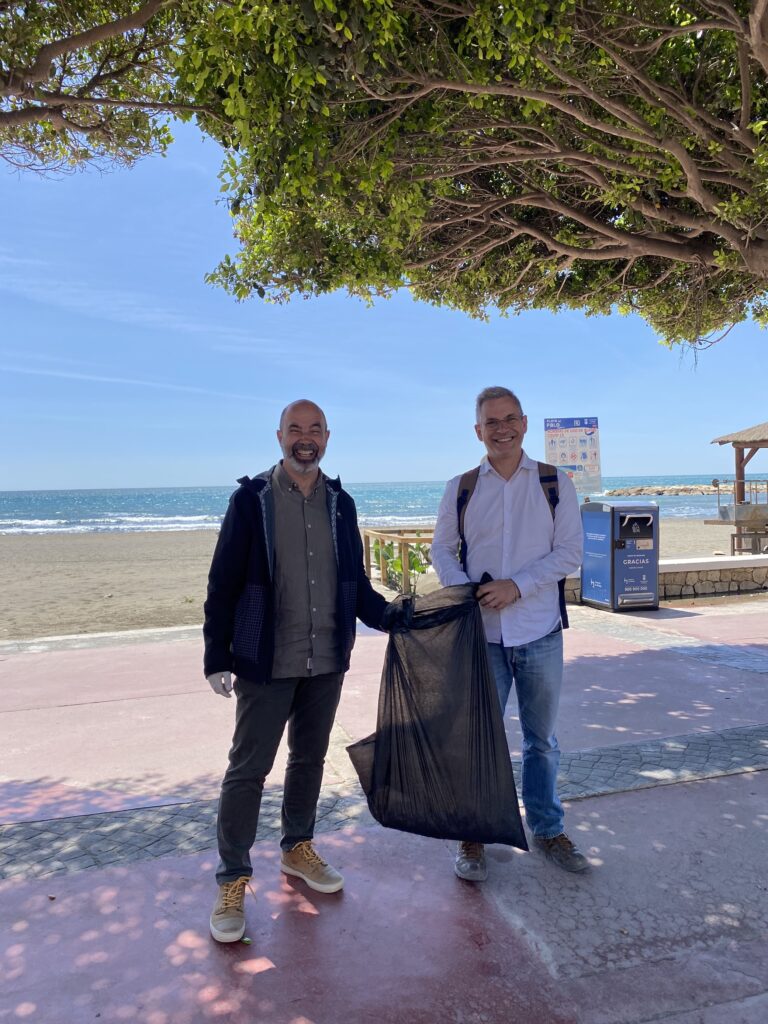 Partners holding rubbish bag after beach clean up 