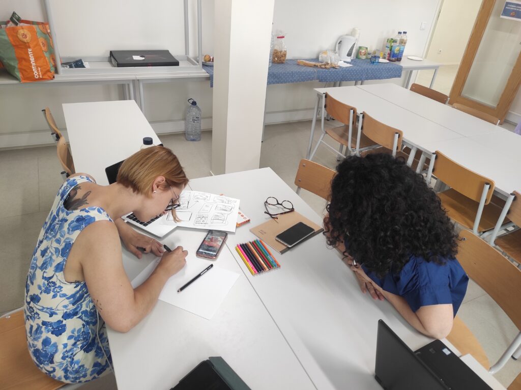 Two participants drawing on paper during classroom workshop