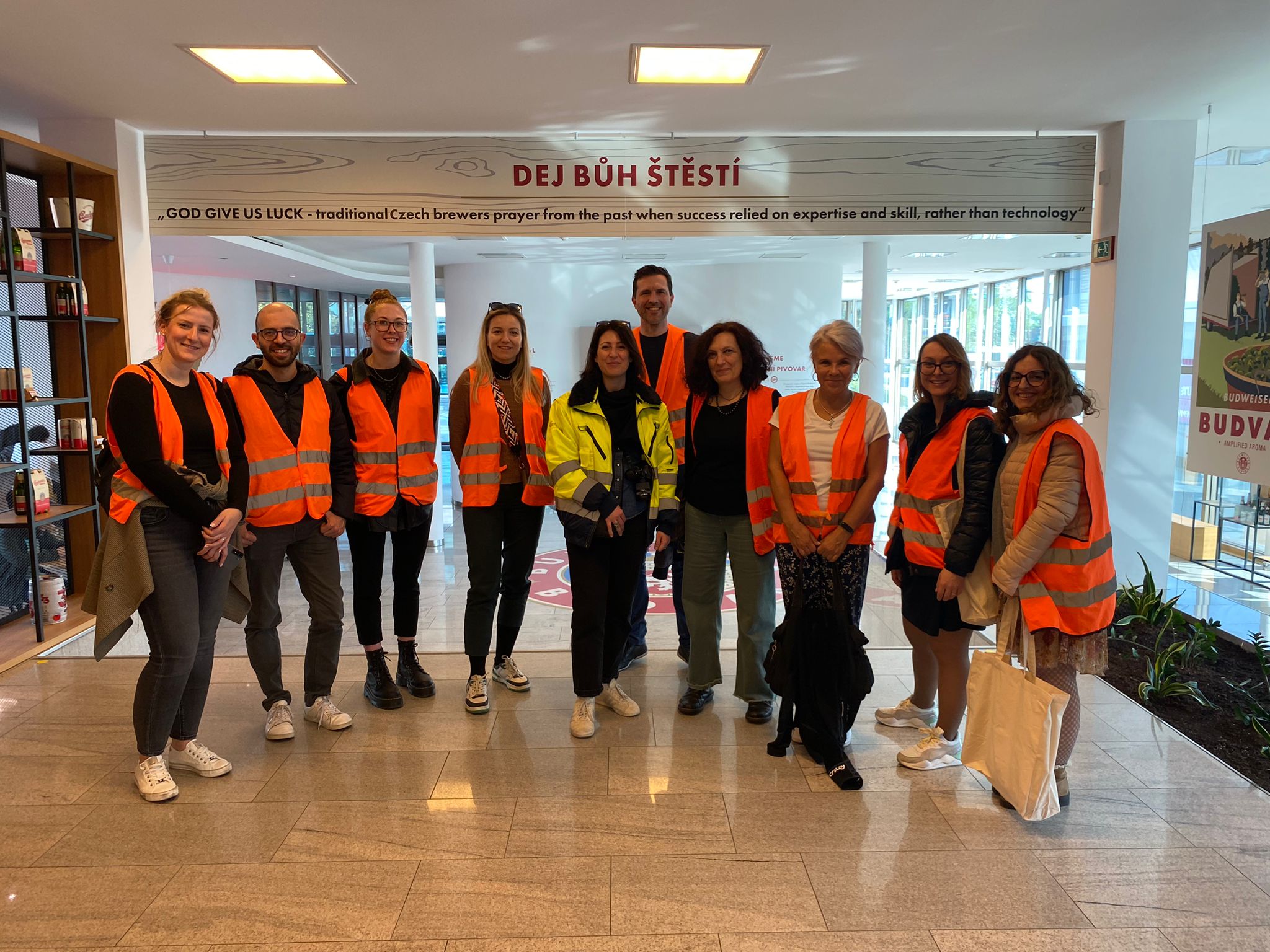 Group photo of project partners wearing orange vests during brewery tour